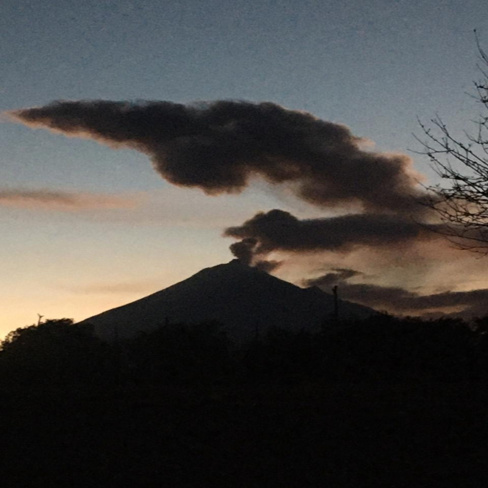 Popocatepetl volcano erupting smoke silhouette at sunset